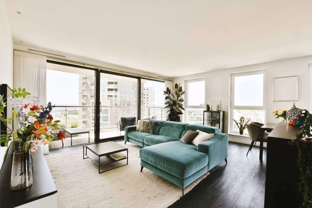 a-living-room-with-a-green-couch-and-large-windows-2025-02-10-11-14-02-Q83UQRM.jpg